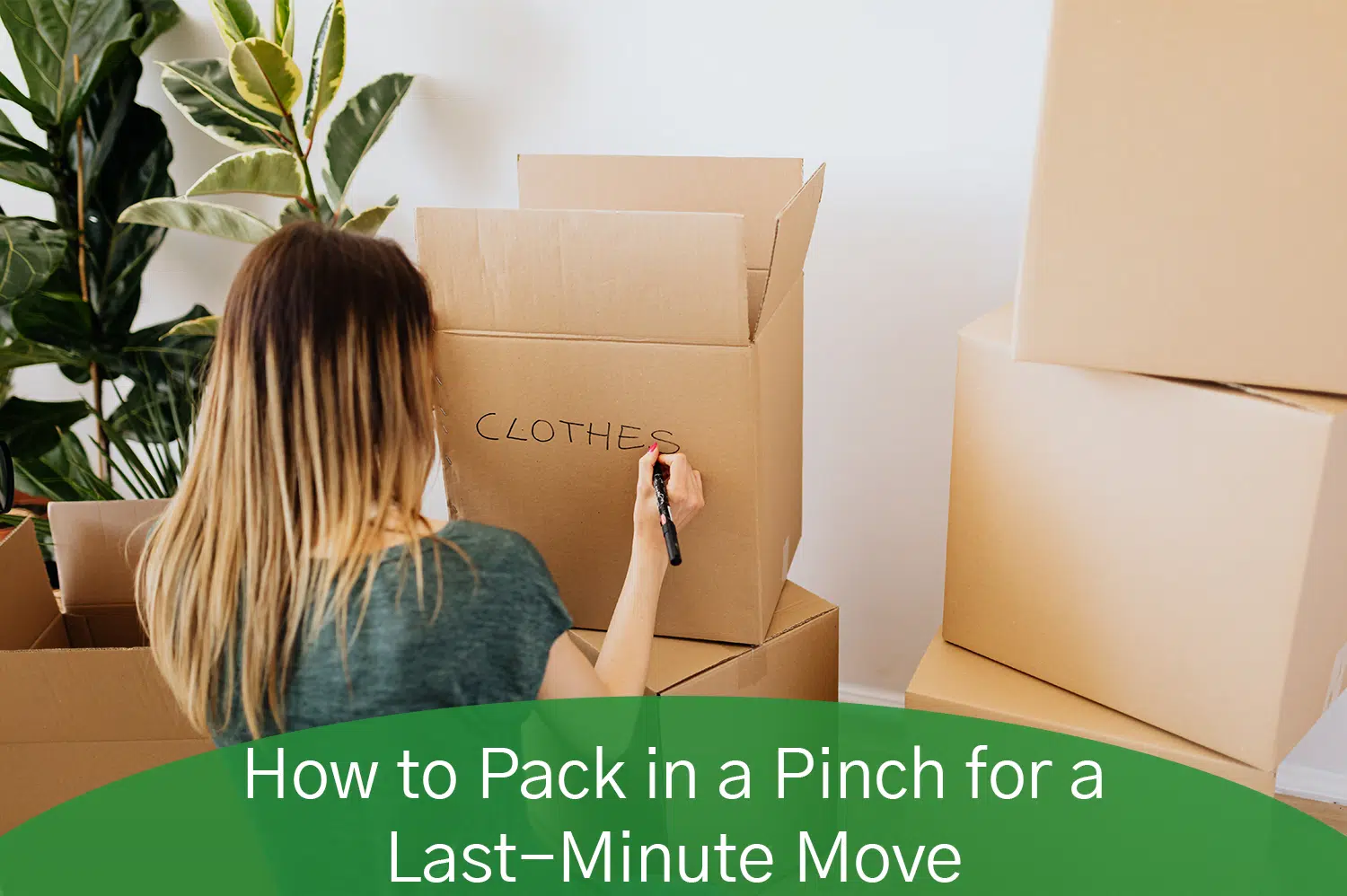 Woman kneeling on ground labeling a cardboard box for a last minute move.