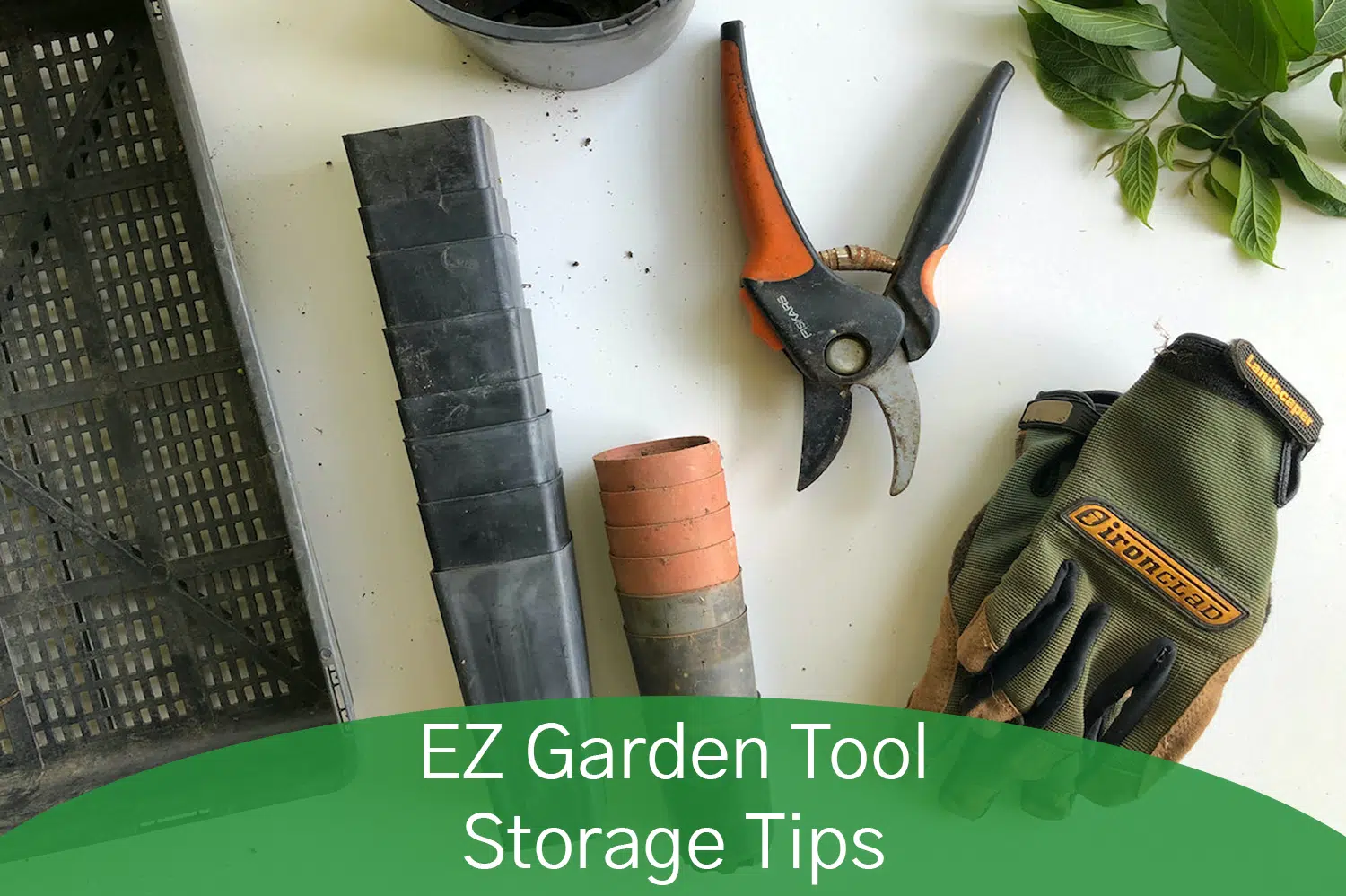 Gardening shears, gloves, tiny pots and plants laying on top of a white table, getting ready for garden tool storage.