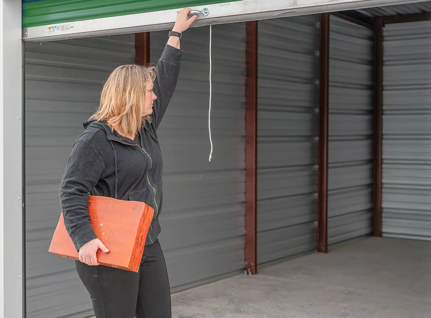 woman opening storage unit roll-up door